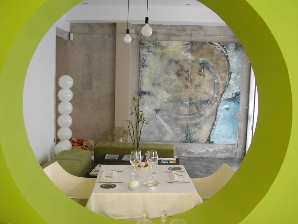 Comedor del restaurante Enoki visto a través de un hueco circular verde