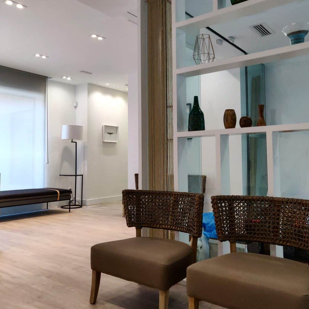 Sala de espera de la clínica de injerto capilar con estantería separadora
