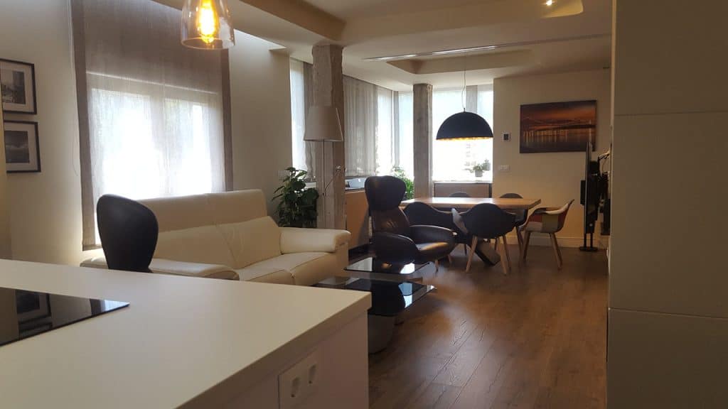 Salón y comedor abiertos con sofá blanco en el apartamento del Batán