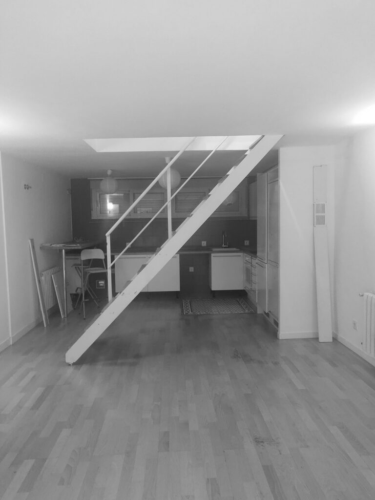 Salón original con la escalera atravesada en el centro de la planta