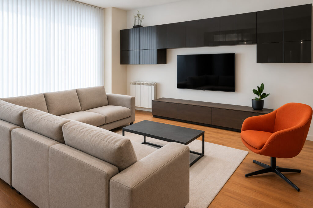 Salón con sofá rinconera, butaca naranja y mueble de televisión negro en Chueca