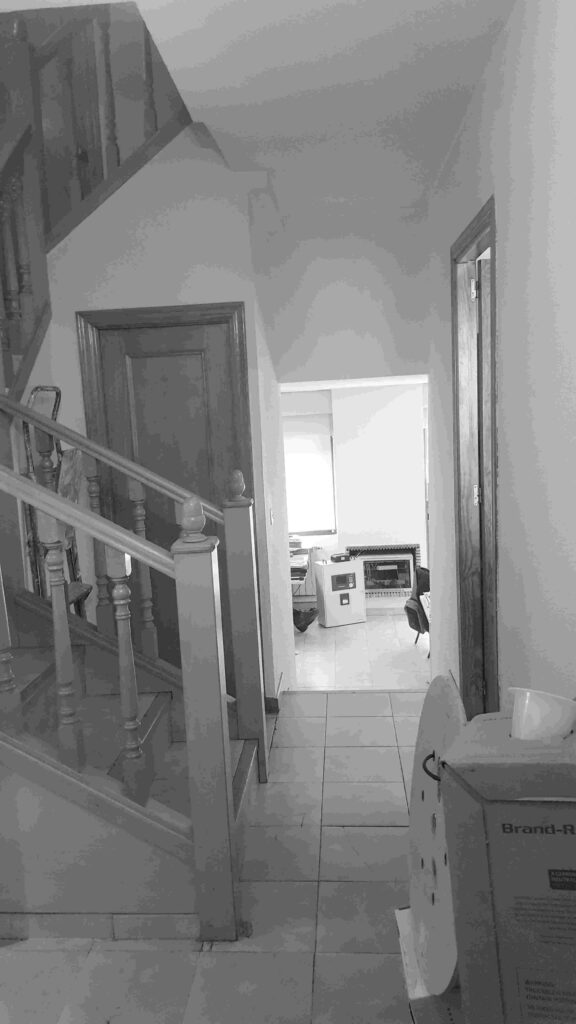 Bajada de tres peldaños desde el distribuidor al salón en el estado original en la casa-estudio de Las Matas
