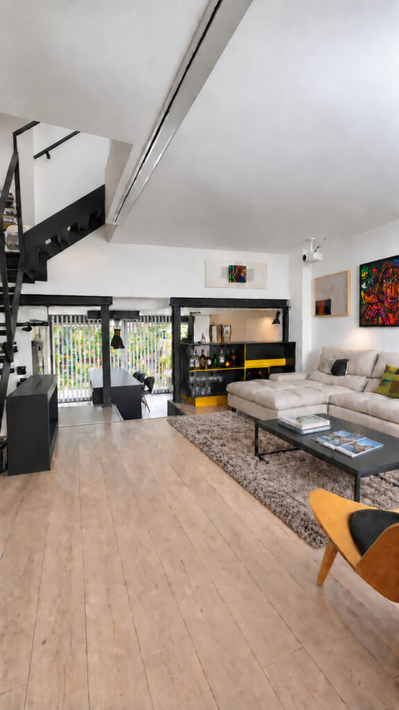 Planta baja abierta con salón, comedor y escalera metálica en la casa-estudio de Las Matas